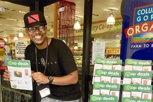 A co-op employee shows off great deals in the Co+op Deals flyer