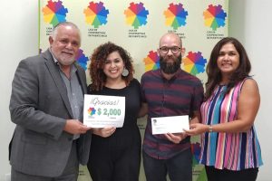La Liga de Cooperativas of Puerto Rico accepts a donation check from food co-ops
