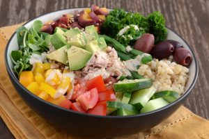 Healthy Buddha-style bowl with veggies, brown rice, tuna and tahini dressing