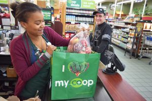 Cashier at food co-op bagging groceries